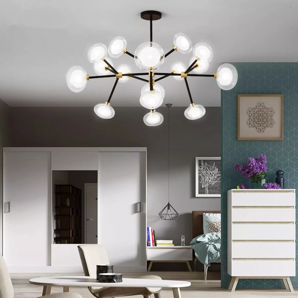A Sputnik Round Glass Style Chandelier with black arms and glowing globe bulbs illuminates a modern, minimalist bedroom.