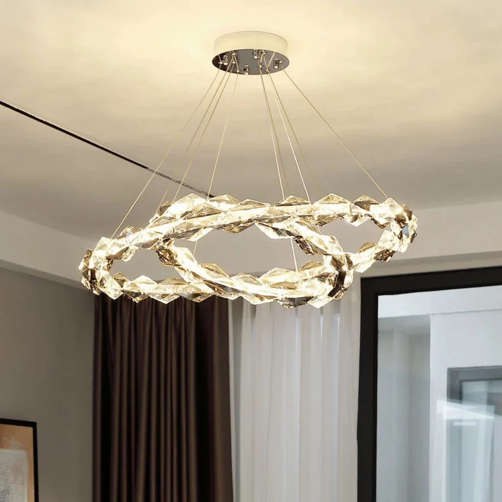 A Crystal Ring Design Chandelier with two interlocking rings of faceted glass, suspended by thin cables in a modern, elegant room.