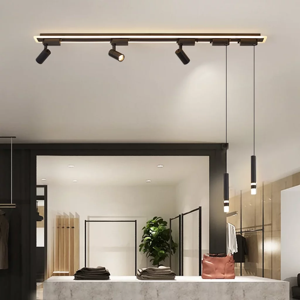 Modern black track light with adjustable spotlights and two sleek pendant lights hanging over a marble counter