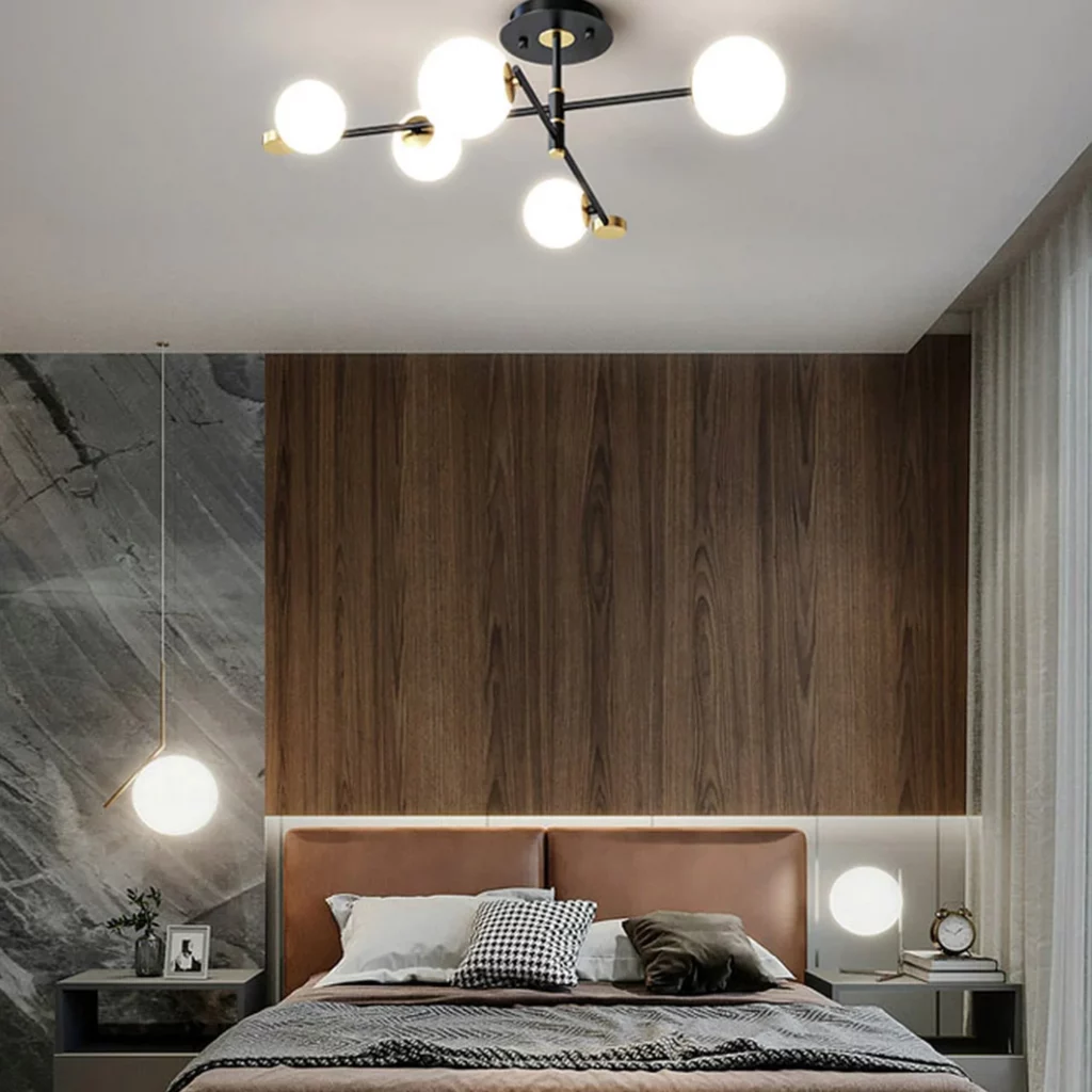 Modern bedroom featuring a wood-paneled headboard, warm minimalist decor, and a Milky White Glass Cross Chandelier illuminating the space above the bed.