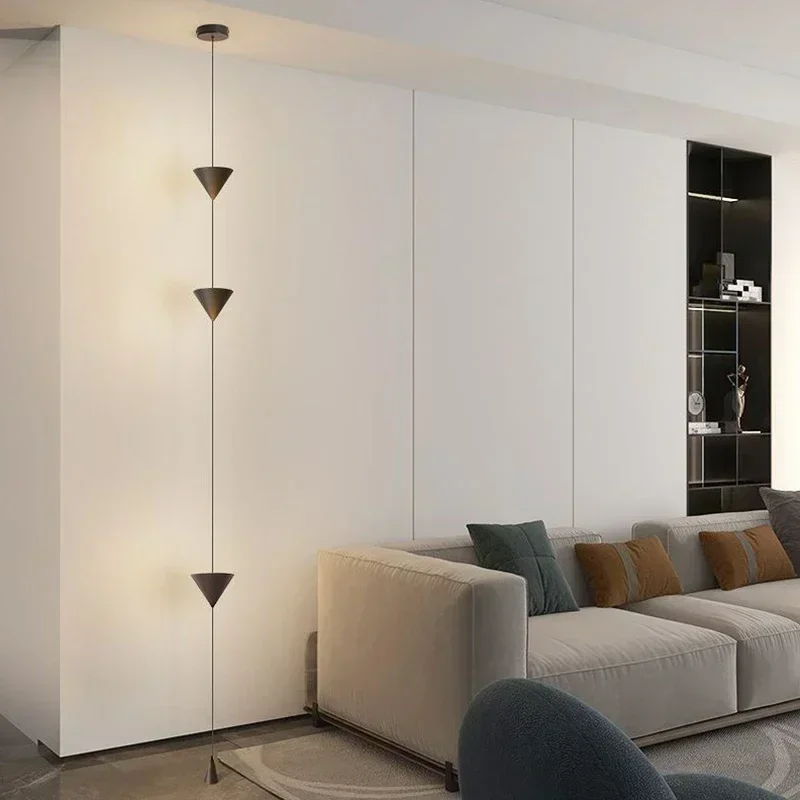 Cone Design Ceiling Floor Lamp with stacked black metal cones in a minimalist living room beside a beige sofa and white paneled wall