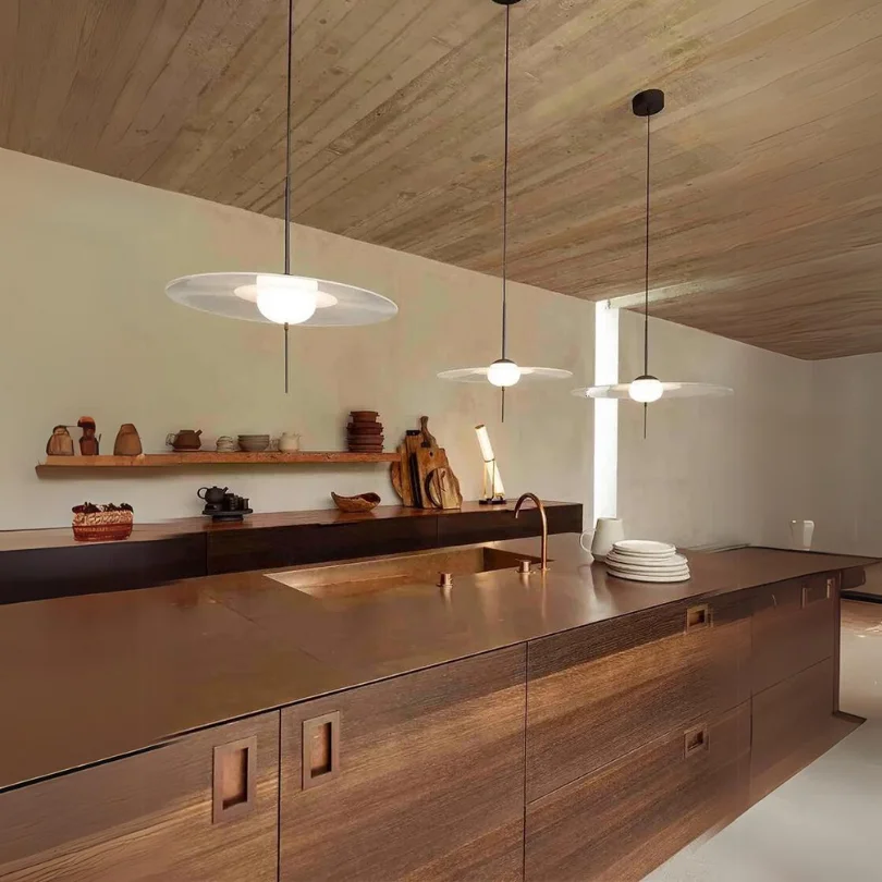 Stylish dining room with teal walls and artwork, illuminated by Lab S Pendant Lamp lights creating warm, artistic ambient lighting.
